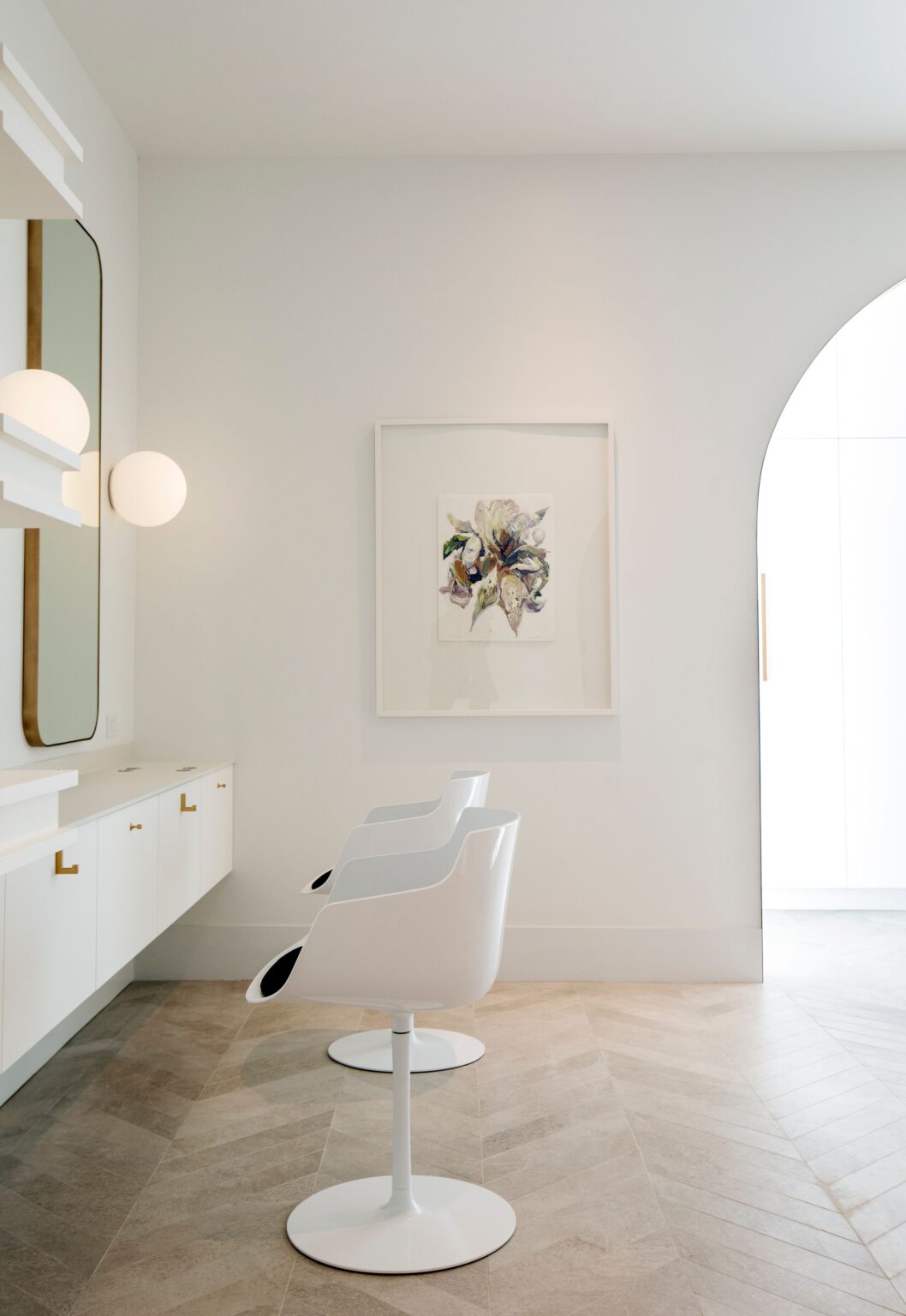 Styling station at Wish Dry Bar with modern white chair, gold-framed mirror, and contemporary lighting